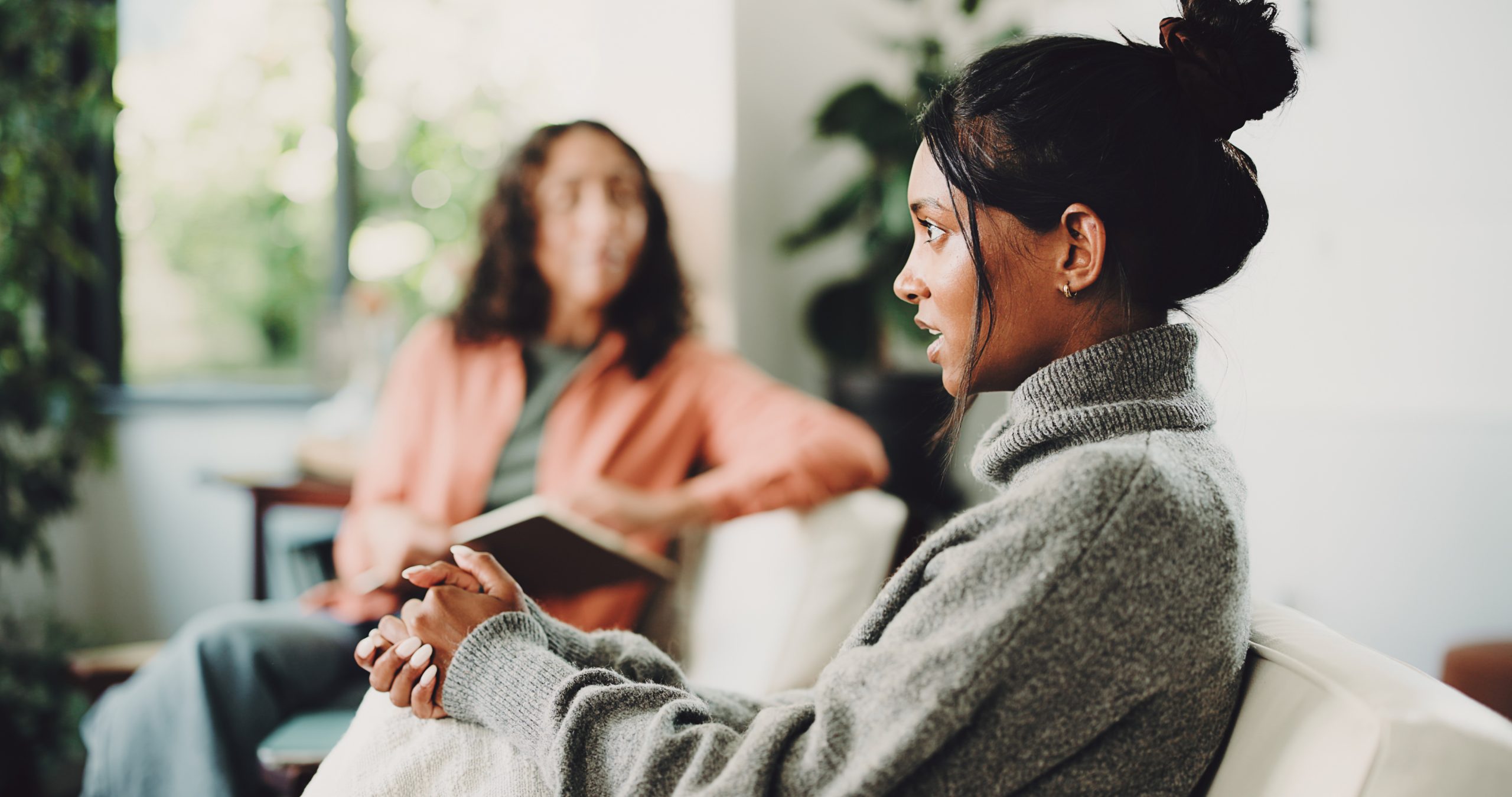 Therapy, conversation and psychologist with patient on sofa in office for mental health support. Counseling, help and psychiatrist talking to woman with depression treatment with healing at clinic